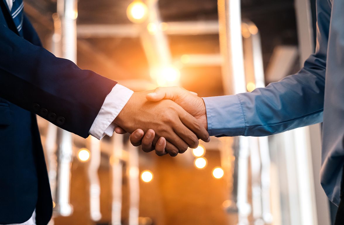 Two individuals shaking hands in suits