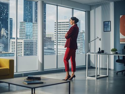 Woman in red suit staring outside window