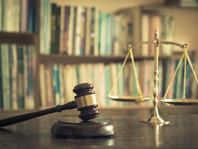 Wooden judge gavel with scales on library