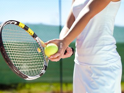 Player holding tennis racket and ball