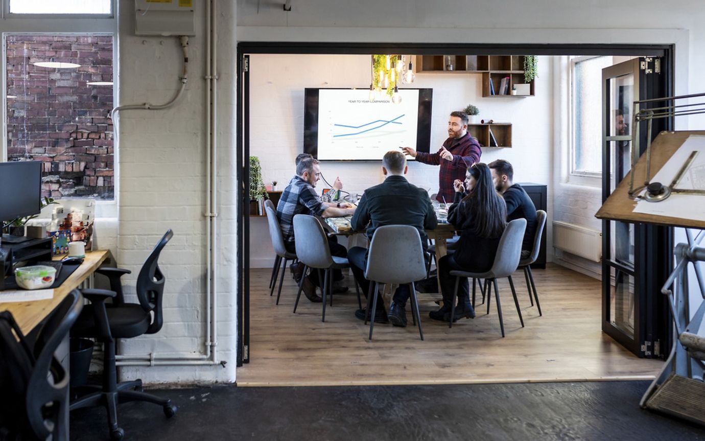 A man is giving a pitch presentation in an office