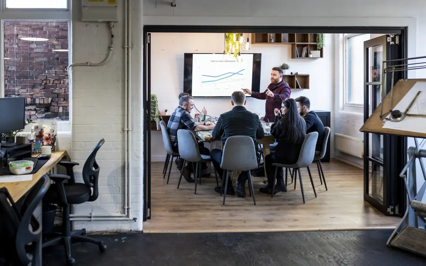 A man is giving a pitch presentation in an office