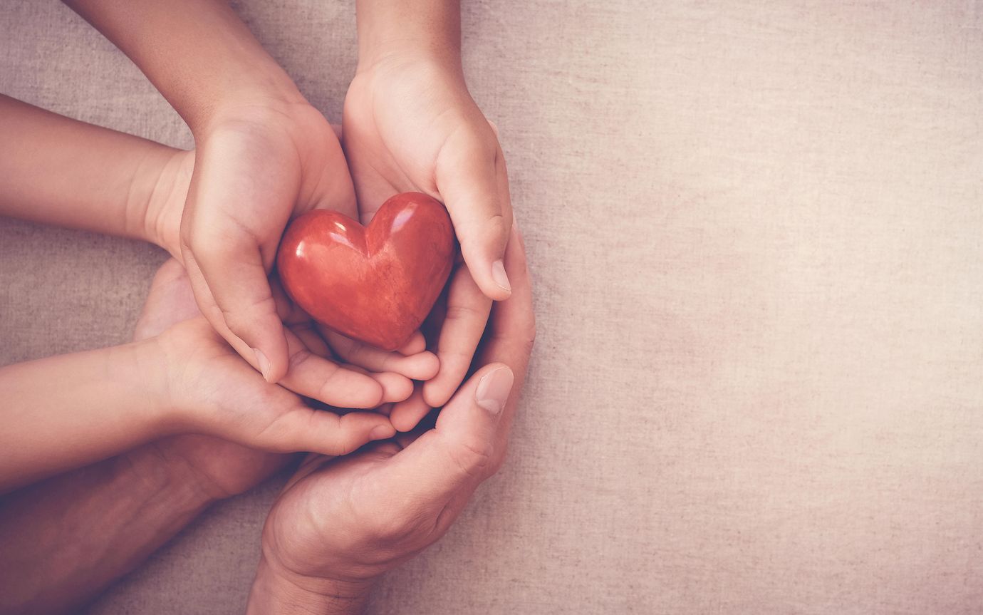 hands holding a wooden heart