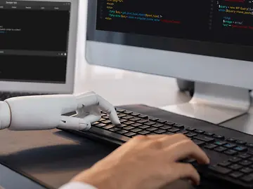 robot and hand on computer