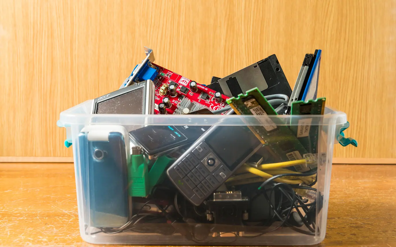 box of old phones and tech