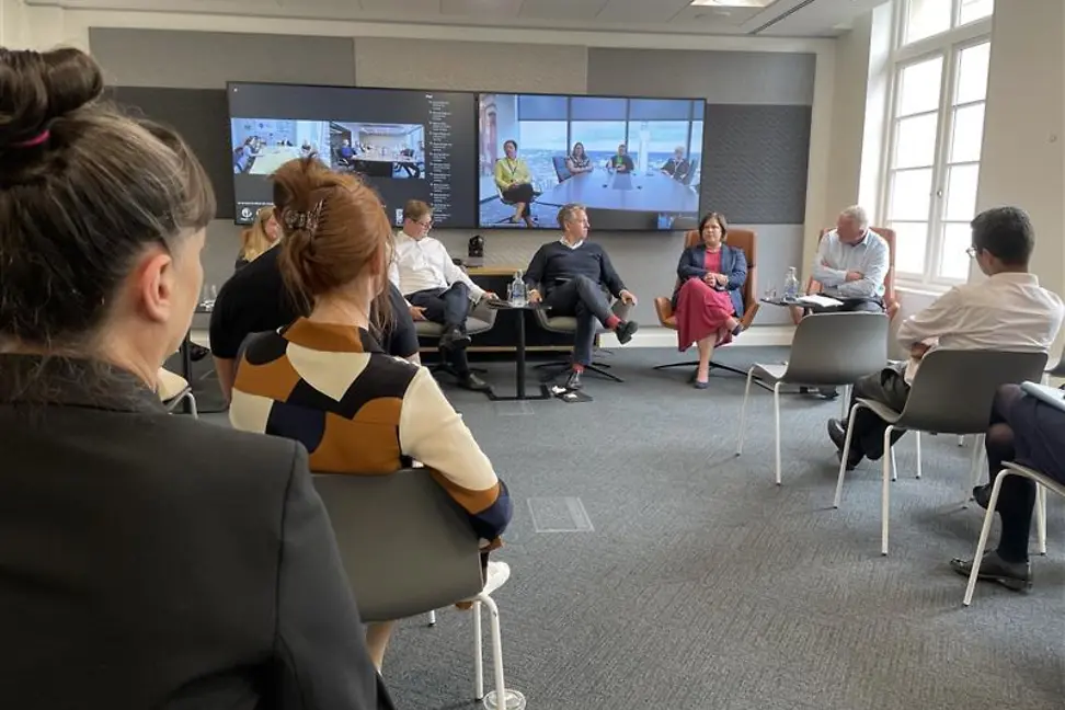 Employees watching the management board talk. 