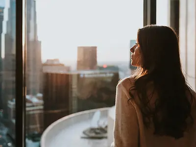 side profile of woman looking outside window