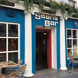 Two white columns flank the entrance to a petrol-coloured house, which contains a bar.