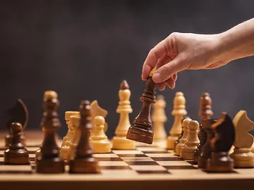 chess piece in a woman's hand on a chessboard in an office