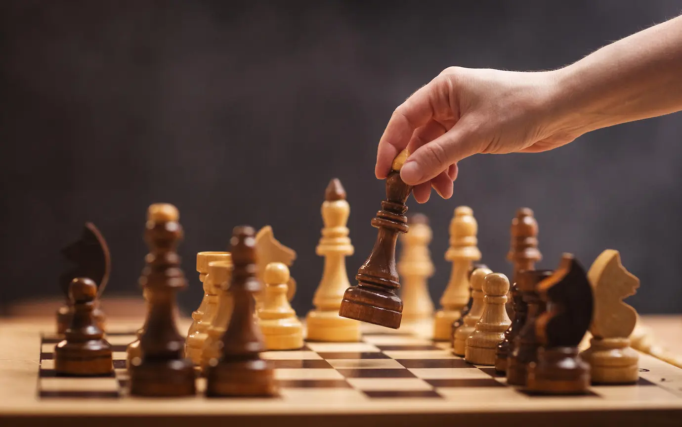 chess piece in a woman's hand on a chessboard in an office