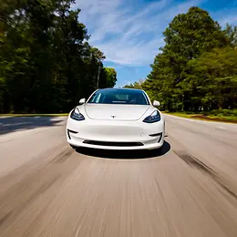 White Tesla driving on road
