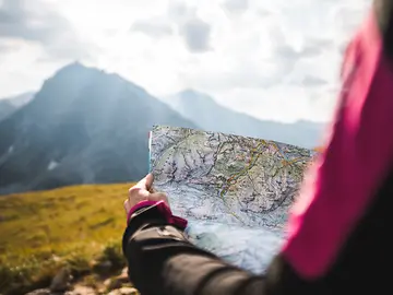 Navigating with map and mountain scene
