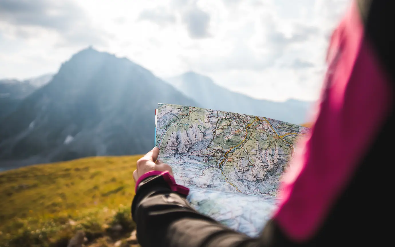 Navigating with map and mountain scene