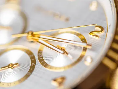 Wrist clock. Close up of a golden clock face with ticking arms.