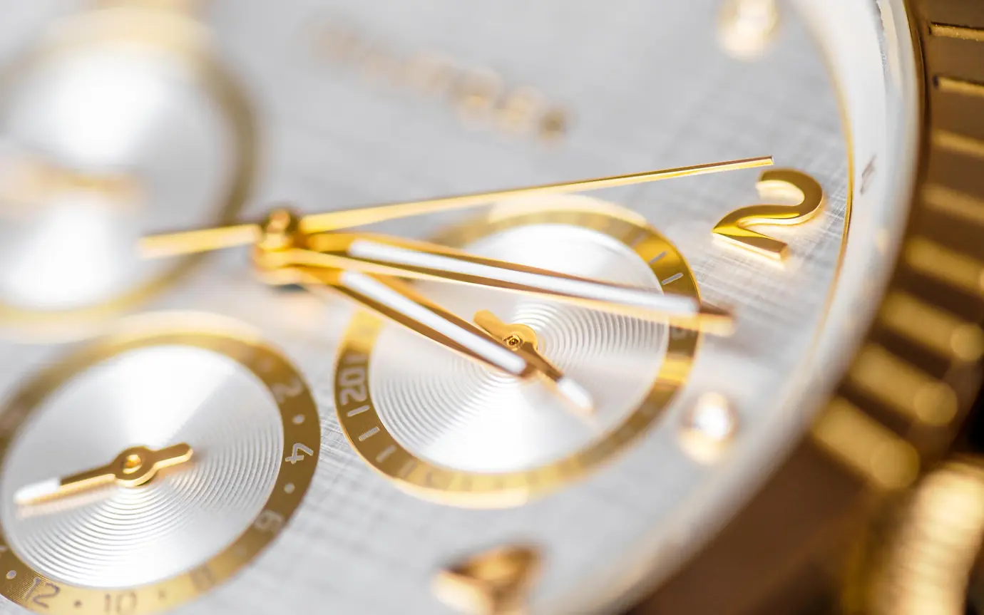 Wrist clock. Close up of a golden clock face with ticking arms.
